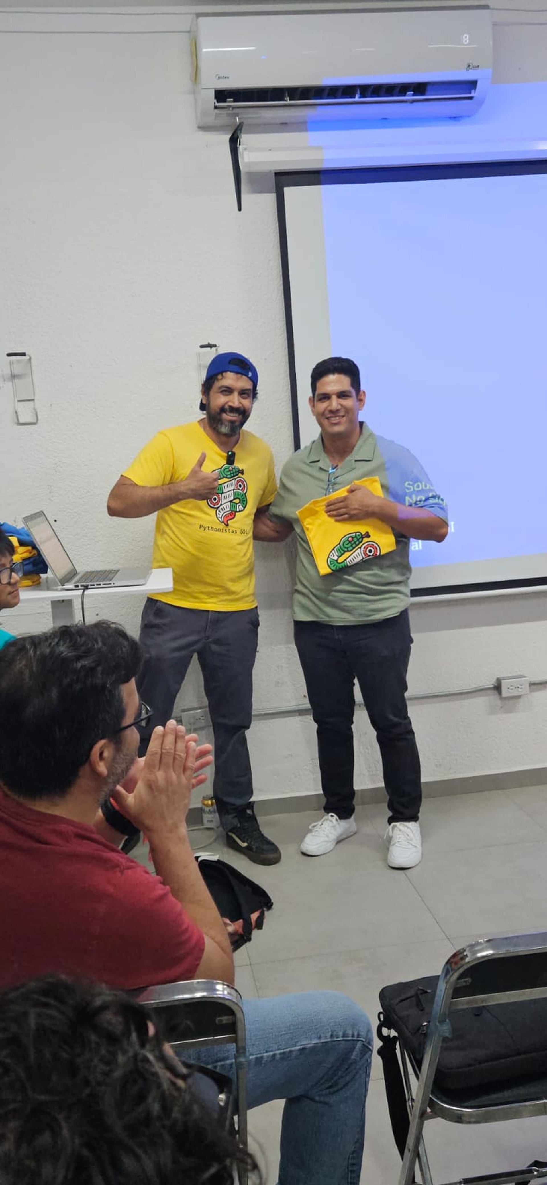 Asistente orgulloso posando con su nueva playera de la comunidad
