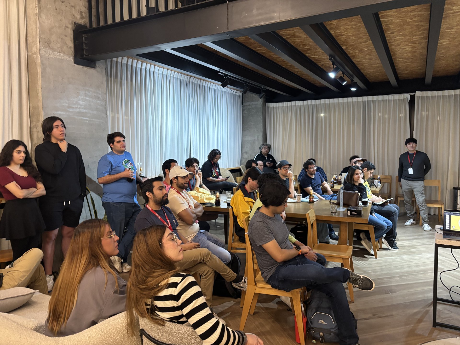 Asistentes interactuando y compartiendo conocimientos en el ambiente colaborativo del evento